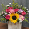 Mixed bouquet with a sunflower, pink roses, and pastel flowers in a gift box