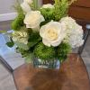 White roses and green chrysanthemums in a square glass vase
