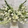 White floral arrangement in a cream urn vase