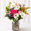 Pink rose and white daisy bouquet in a glass jar vase