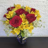 Red roses and yellow alstroemeria in a glass vase