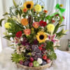 Mixed flower basket with sunflowers, lilies, roses, and fruit