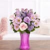 Pink and lavender mixed bouquet in a purple glass vase