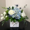 White roses and blue hydrangeas in a white wooden box