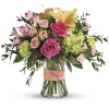 Bouquet of pink roses, lilies, and green hydrangeas in a glass vase