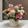 A cheerful, garden-inspired arrangement bursting with Pinks, Coral, and Cream. Featuring Roses
