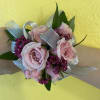 Pink rose wrist corsage with purple accent flowers and silver ribbon