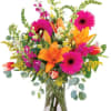 Bright mixed bouquet with orange lilies and pink gerbera daisies in a clear vase