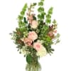 Tall pink and white floral arrangement in a clear glass vase