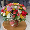 Mixed bouquet of roses, carnations, and chrysanthemums in a painted ceramic vase