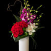 Red roses and purple orchids in a white vase