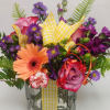 Mixed bouquet in a clear glass vase with pink, purple, and peach flowers