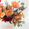 Bouquet of orange and red flowers in a white vase