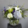 A unique color palette using blue hydrangea, white lilies, white roses and