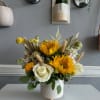 Yellow and white floral arrangement in a white ceramic pot
