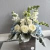 White roses and blue hydrangeas in a wooden box with tall white blooms