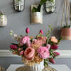 Pink and peach floral arrangement in a white vase