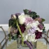 Mixed bouquet in a clear square vase with white, pink, and purple blooms