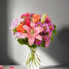 Pink and orange mixed bouquet in a clear glass vase