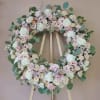 Pastel floral wreath on a wooden easel
