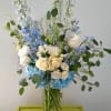 A tall and full arrangement featuring hydrangeas, hybrid delphinium, roses, lisianthus and