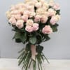 Large hand-tied bouquet of pale pink roses with long stems and a pink ribbon