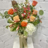 Orange and peach roses with white hydrangeas in a glass vase