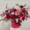 Large bouquet of red and pink roses in a pink hat box