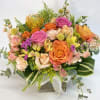Mixed bouquet of orange and pink roses in a wooden box