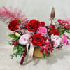 Mixed bouquet of red and pink roses in a gold vase
