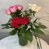 Bouquet of pink, red, and white roses in a glass vase