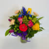 Colorful mixed bouquet in a glass vase with ribbon