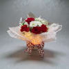 Bouquet of red roses, white daisies, and red carnations with a heart-pattern ribbon