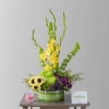 Yellow gladiolus and sunflowers in a striped green container