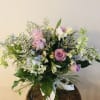 Bouquet of pink and lavender roses with white flowers in a glass vase