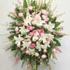 Large pink and white floral standing spray on an easel