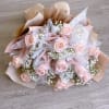 Bouquet of pale pink roses with white baby's breath in blush and beige wrap
