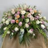 Large pastel bouquet of roses and carnations with trailing greenery