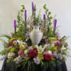Large floral arrangement with a white urn centerpiece and mixed blooms