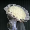 Large bouquet of white roses wrapped in clear plastic with ribbon