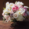 Clear vase with white, and pastel pinks flowers like 
roses, spray rose