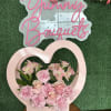 Pink floral arrangement in a heart-shaped box with roses and carnations