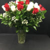 Red and white roses arranged in a clear glass vase