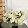 White roses and hydrangeas in a clear glass vase