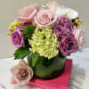 Pink and lavender roses with hydrangea in a glass vase