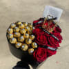 Heart-shaped box with red roses and gold-wrapped chocolates