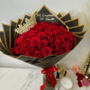Bouquet of red roses with a jeweled crown and black-and-gold wrapping