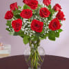 Bouquet of red roses and white baby's breath in a clear glass vase