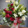 Bouquet of red and white roses with lilies in a white vase