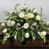 White floral casket spray with roses and lilies
